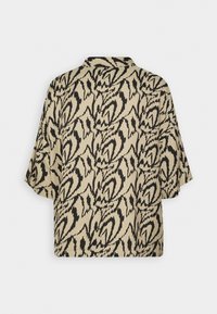 Chemise beige à manches courtes avec un large col présentant un motif abstrait de coups de pinceau noirs, vue de dos.