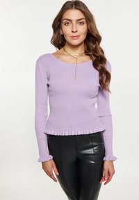 Maglione ribbed lilla con un design aderente, maniche con volant e orlo, abbinato a pantaloni in finta pelle nera lucida.