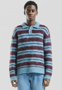 Pasiasty sweter z dzianiny w naprzemienne kolory niebieski i bordowy, z kołnierzem zapinanym na guzik i miękką, puszystą fakturą.