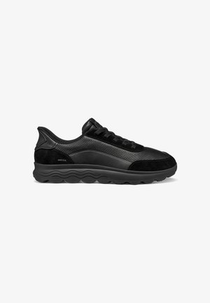 Sneaker nero basso in pelle traforata, dettagli in camoscio, design con lacci, suola imbottita e suola esterna con motivo onde, vista laterale.
