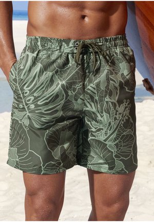 Green swim shorts with a botanical leaf pattern, featuring a drawstring waist, side pockets, and a smooth, lightweight fabric.