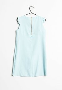 Ljusblå ärmlös klänning med en volang på axeln, dragkedja i ryggen och en mittbåge. Slät tyg med en enkel, strukturerad design.