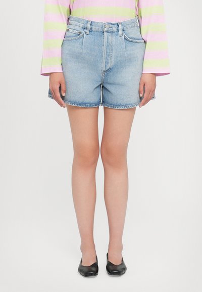 Shorts en denim bleu clair, taille haute avec un ourlet effiloché. Dispose de poches avant et d'une fermeture à bouton classique. Texture lisse.