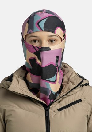 Multicolored balaclava made of stretchy fabric with abstract geometric patterns in pink, black, and blue, paired with a beige jacket.