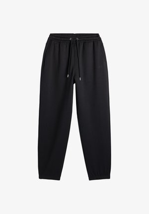 Zwarte joggingbroek met elastische tailleband, koordje, zijzakken en elastische boorden bij de enkels, plat uitgestald op een witte achtergrond.