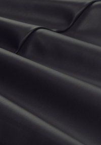 Smooth, dark black synthetic leather fabric with gentle folds and subtle grain texture visible across the surface.