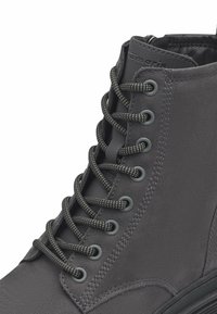 Stivale alla caviglia grigio realizzato in pelle texture, con lacci tondi, occhielli metallici e una suola in gomma bassa con un leggero motivo di battistrada.