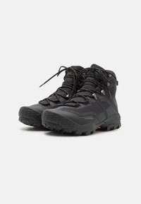 Bottes de randonnée noires avec dessus en mesh, semelle en caoutchouc, support de cheville haut et système de laçage intégré pour un maintien sécurisé.