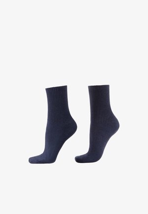 Marineblauwe katoenen sokken met een geribd ontwerp, tot halverwege de kuit, en verstevigde hiel. Gladde textuur, eenvoudige vorm.