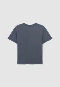 Maglietta in cotone grigia con collo rotondo, maniche corte e vestibilità rilassata. Presenta una texture morbida e dettagli con orlo non rifinito al colletto.