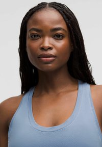 Jasnoniebieski top bez rękawów z okrągłym dekoltem i gładką teksturą, z szerokimi ramiączkami i dopasowanym krojem.