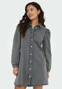 Robe en denim gris avec un devant boutonné, des manches longues et un col. Présente une coupe droite et des détails de couture subtils.