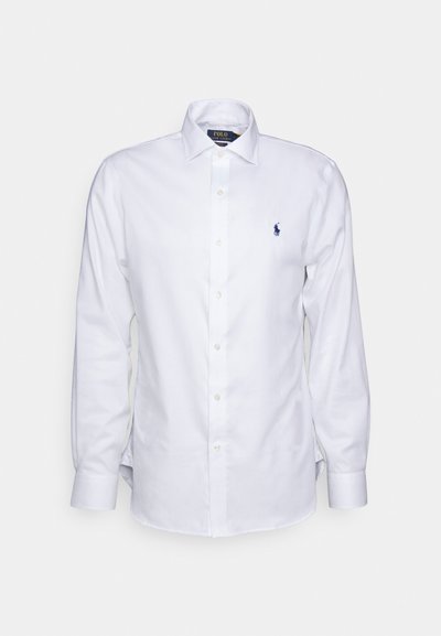 White long-sleeve shirt made of cotton, featuring a button-down collar and a small navy embroidered logo on the left chest.