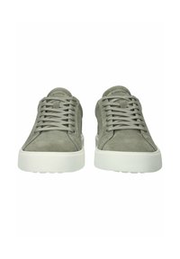 Paar grijze suède sneakers met witte rubberen zolen en veters, gezien van voren op een witte achtergrond.