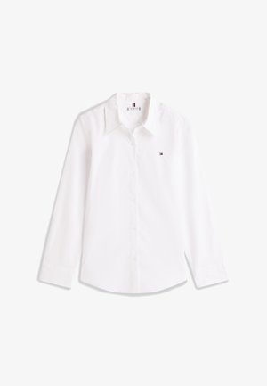 Vit skjorta med lång ärm och knappar framtill, med spetsig krage och liten Tommy Hilfiger-logotyp på vänster bröst.