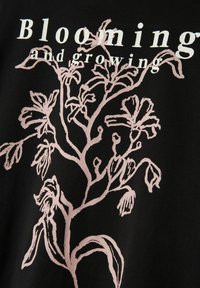 Stilisiertes blasses pinkes Blumen-Skizze mit dem Text "Blühen und Wachsen" auf schwarzem Stoffhintergrund.