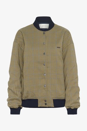 Καπιτονέ μπουφάν τύπου bomber σε κίτρινο και ναυτικό μπλε καρό σχέδιο, με ριμπ γιακά, κουμπιά με κλιπ και ελαστικά μανίκια για άψογη εφαρμογή.