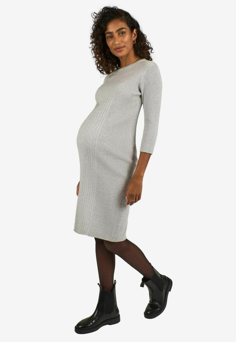 Rochie midi gri cu dungi, cu mâneci trei sferturi, siluetă ajustată, purtată cu botine negre și pe deasupra colanți negri.