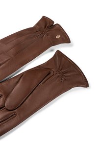 Un par de guantes de cuero marrón con tres líneas cosidas en la parte trasera y un elástico gather en la muñeca, sobre un fondo blanco.