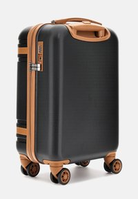 Valigia rigida nera con finitura testurizzata, dettagli in beige, doppie cerniere e quattro ruote per la mobilità. Design compatto e resistente.