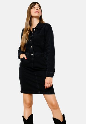 Vestido de mezclilla negro con mangas largas, delante con botones y cintura ceñida con cinturón. Presenta un bolsillo en el pecho y una textura suave. Puños ajustables.