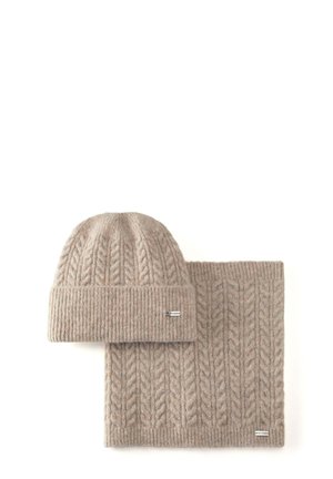 Gorro de punto grueso beige con puño acanalado y bufanda rectangular a juego, mostrado sobre un fondo blanco.