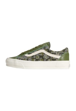 Zapatilla de corte bajo con estampado de bandana verde oliva, franja lateral blanca, detalles en cuero verde y suela gruesa blanca de goma.