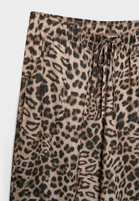 Kalhoty s leopardím vzorem mají měkkou, lehkou tkaninu s černým elastickým pasem a šňůrkou, která ukazuje směs hnědých a černých skvrn.