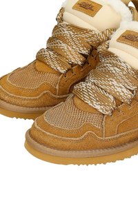 Suwakowe sneakersy z zamszu i tkaniny, z grubymi podeszwami, teksturowanym splotem i beżową futrzaną podszewką. Posiadają grube, wzorzyste sznurówki oraz metkę z logo.