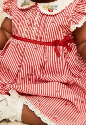 Robe pour bébé rayée rouge et blanche avec broderie florale, manches et col bordés de dentelle, et un nœud en ruban rouge à la taille.