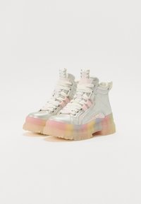 Zapatillas altas plateadas con un acabado brillante, acentos en tonos pastel, suela translúcida y gruesa, cordones estampados y un detalle de logo en la lengüeta.