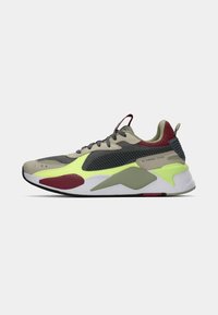 Puma RS running shoes feature a mesh upper in grey and beige with neon green accents, a red detailing near the sole, and a padded collar for comfort.