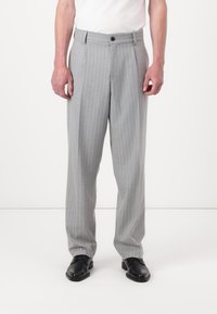 Gray pinstriped trousers with a tailored fit, featuring a button front closure and side pockets, paired with black dress shoes.