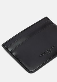 Czarny skórzany etui na karty z wieloma przegródkami, gładką teksturą i wytłoczonym logo marki. Obszycie wzdłuż krawędzi dodaje detalu.