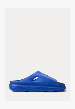 Μπλε σανδάλι με κλειστό επάνω μέρος, οπές αερισμού και χονδρό πάτο, απεικονισμένο στο πλάι σε λευκό φόντο.