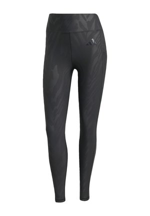 Leggings neri con un motivo a zebra tonale, vita alta, texture liscia e logo Adidas sulla coscia sinistra. Realizzati in tessuto elasticizzato.