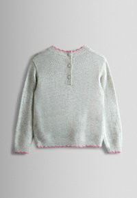 Vaaleanharmaa neulepusero, jossa on henley-tyylinen kaulus ja kolme nappia. Kauluksessa ja helmassa pinkki röyhelöreuna. Pitkät hihat, pehmeä rakenne.