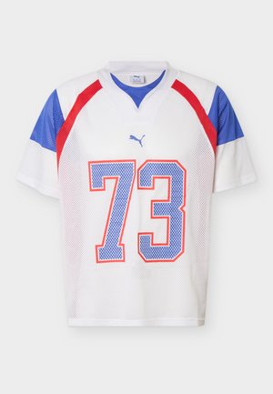 Valge võrguline spordisärk siniste ja punaste aktsentidega, millel on number 73 sinisega, mida ääristab punane ning väike Puma logo üleval.