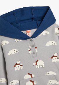 Sudadera gris para niños con capucha azul y botones, que presenta osos polares blancos, algunos con bufandas rojas, en varias posturas.