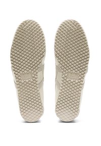 Beżowe sneakersy z teksturowaną gumową podeszwą, z diamentowym wzorem i subtelnym logo z boku. Gładki materiał o minimalistycznym designie.