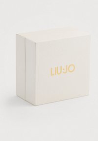 Cremefarvet rektangulær kasse med guld "LIU·JO" logo centralt placeret på fronten, sat mod en ensfarvet hvid baggrund.
