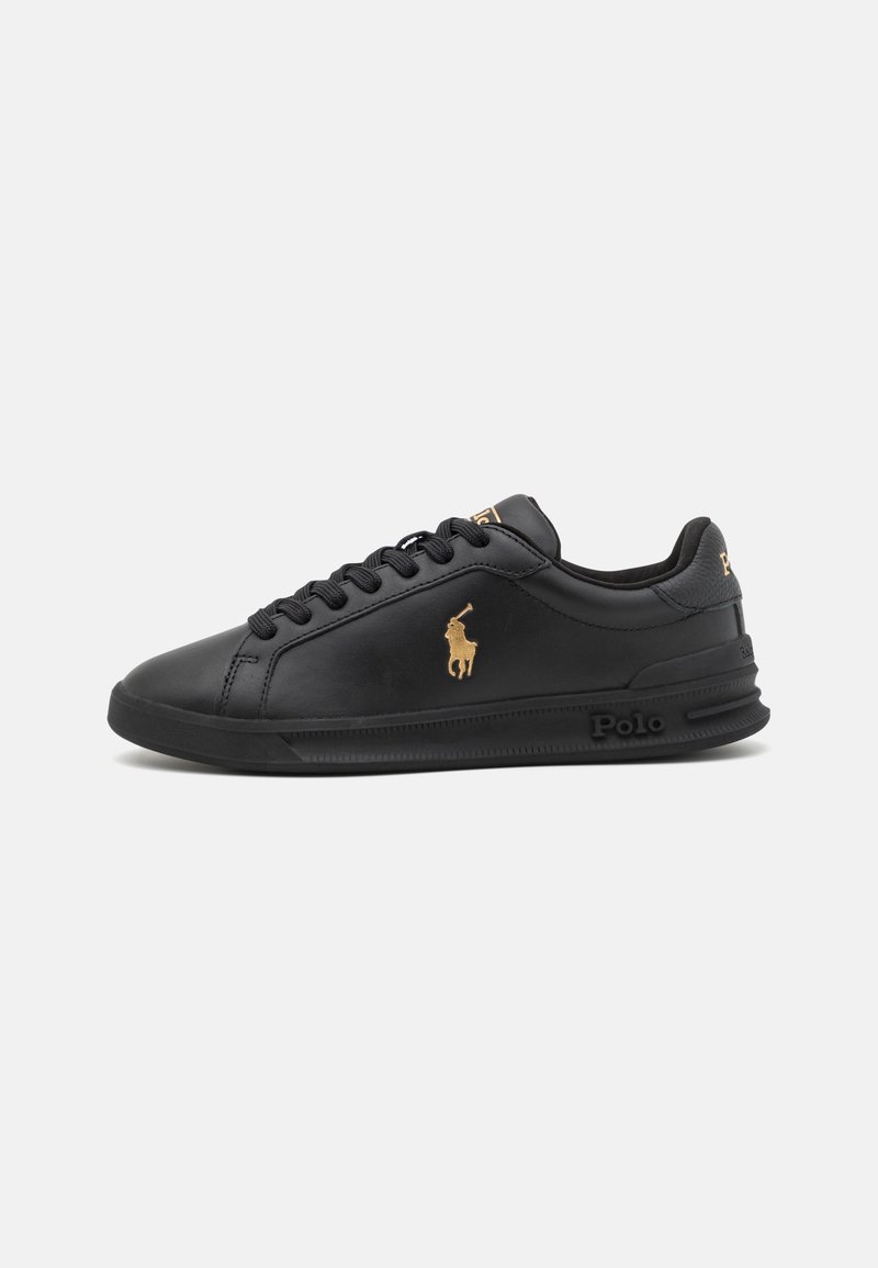 Baskets basses noires avec lacets noirs, logo Polo doré sur le côté, et marquage en relief "Polo" sur la semelle, sur fond blanc.
