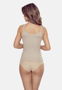 Beżowy, prążkowany top na ramiączkach z cienkimi paskami. Gładka faktura i dopasowany krój, w komplecie z pasującą beżową bielizną. Prosty i minimalistyczny styl.