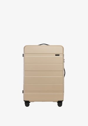 Hartschalengepäck in Beige mit horizontalen Rillen, schwarzen Akzenten, seitlichem Griff und vier leicht rollenden Rädern für eine einfache Manövrierbarkeit.