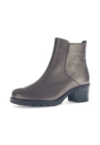 Bruine leren enkelboot met een ronde neus en een gestructureerd oppervlak, voorzien van een blokhak en een rubberen zool voor grip.