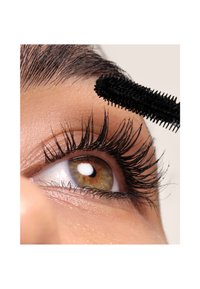 Nahaufnahme eines Auges mit langen, schwarzen Wimpern, während eine schwarze Mascara-Bürste aufgetragen wird. Das Auge ist braun mit einem weißen Akzent.