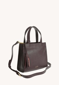 Sac à main en cuir brun foncé avec deux poignées courtes, une bandoulière détachable, un détail de pampille et un texte de marque doré à l'avant.