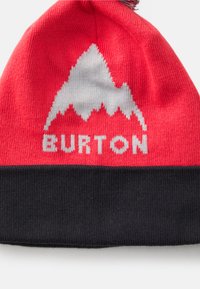 Gebreide beanie in felrood met een zwarte boord. Heeft een bergafbeelding in het wit en het woord "BURTON" in witte letters aan de voorkant.