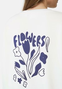 Witte sweatshirt met een marineblauw bloemgrafiek en het woord "BLOEMEN" in een gedurfde, speelse lettertype, geïllustreerd in een abstracte stijl.