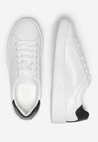Sneakers bianche in pelle con punta arrotondata, suola piatta e accentuazione nera sul tallone. Presentano lacci e cuciture minime per un design pulito.